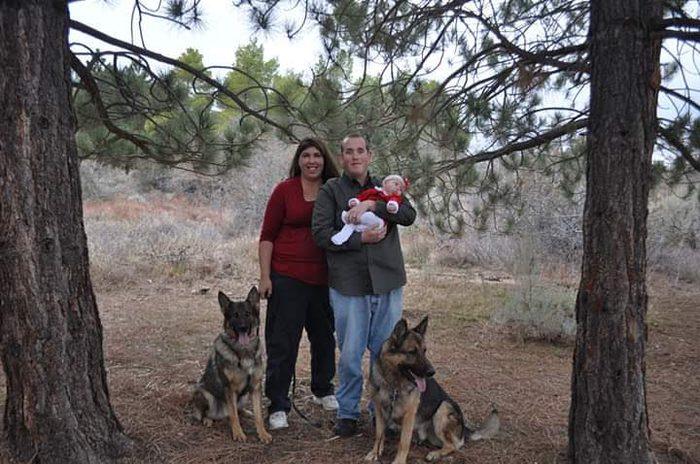 Lynne and her husband with their baby and two German Shepherds
