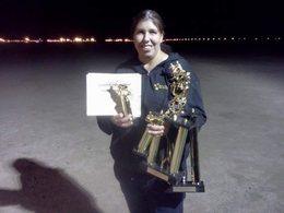 Lynne holding competition trophies and a certificate at a Schutzhund event
