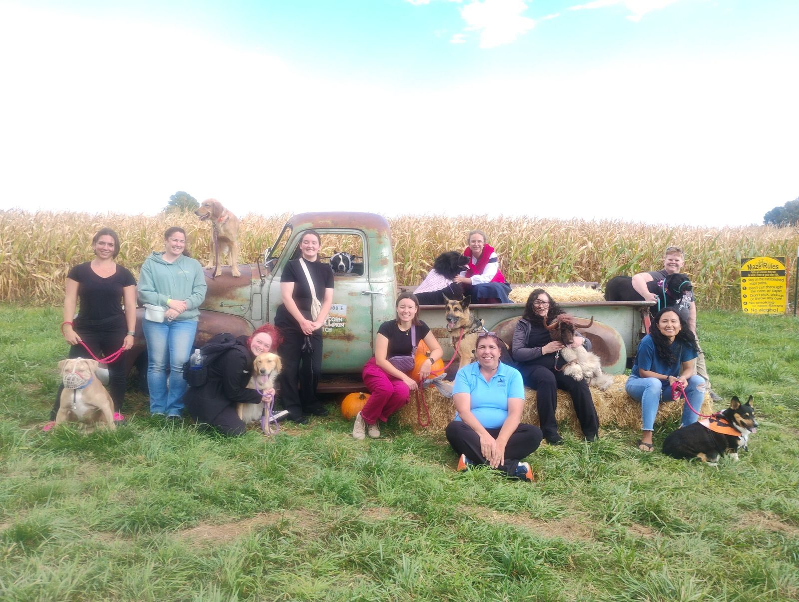 Dog training demo team and their dogs gathered around a vintage truck at a corn maze field trip in the Uintah Basin